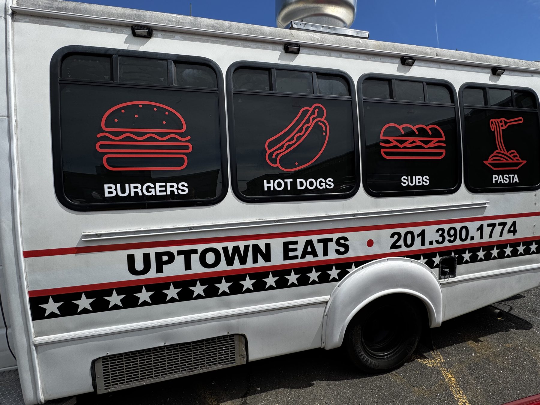 Uptown Eats food truck side view with menu icons